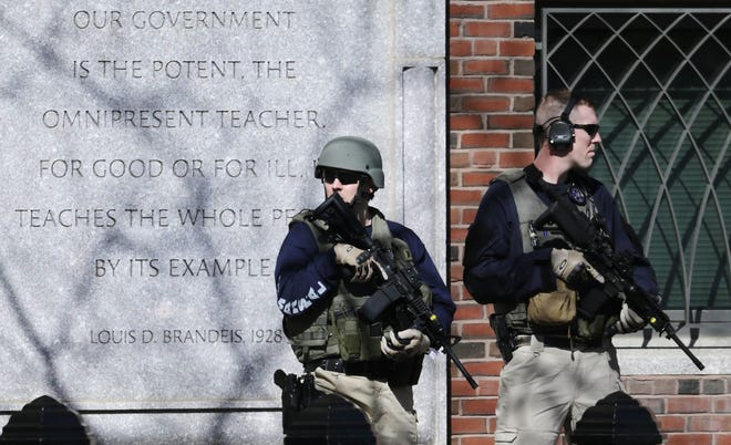 U.S. Marshals in tactical gear stand guard outside Boston's Moakley Federal Court House after if was evacuated on Wednesday. The building was evacuated amid conflicting reports that a suspect in the Boston Marathon bombing is in custody. AP Photo/Charles Krupa
