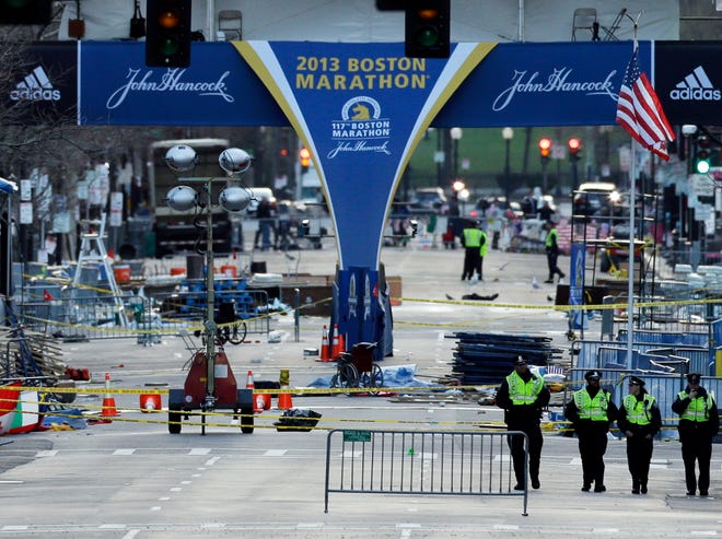 Police officers walk on Boylston Street near the finish line of Monday's Boston Marathon explosions, which killed at least three and injured more than 140, Thursday, April 18, 2013, in Boston. (AP Photo/Matt Rourke)