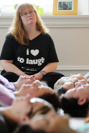 "It’s all really positive. There's no pointing or making fun of anyone," says Elizabeth Venart of laughter yoga. Here, she leads participants through a relaxing meditation at the end of class.