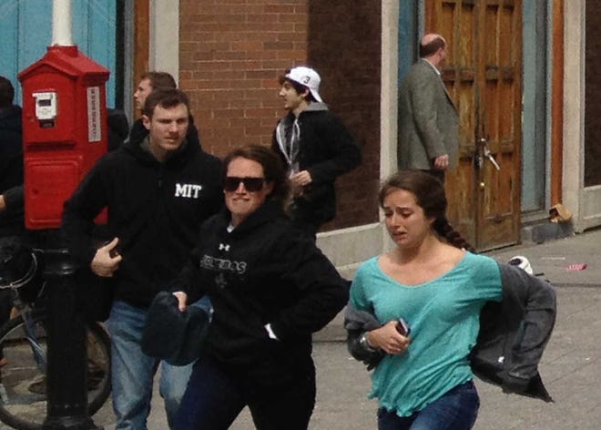 This Monday, April 15, 2013, shows a man who was dubbed Suspect No. 2 in the Boston Marathon bombings by law enforcement, in the upper center of the frame, wearing a white baseball cap, walking away from the scene of the explosions. The FBI identified him as 19-year-old college student Dzhokhar Tsarnaev, who along with his brother Tamerlan, 26, previously known as Suspect No. 1, killed an MIT police officer, severely wounded another lawman and hurled explosives at police in a car chase and gun battle during a night of violence, early Friday, April 19, 2013. Tamerlan Tsarnaev was killed overnight, officials said, while his brother Dzhokhar remains at large. (AP Photo/David Green)