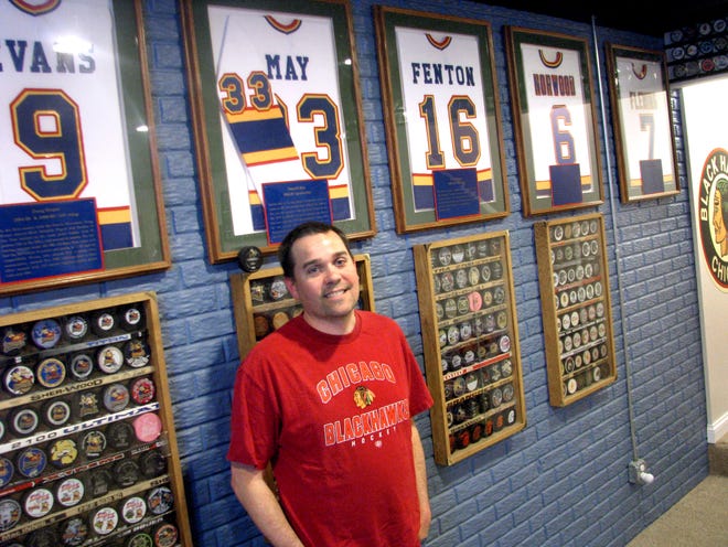 Andy Schmidgall of Washington pauses by his basement hockey shrine, highlighted by autographed jerseys from Peoria Rivermen all-time greats. Schmidgall, who buys and sells memorabilia of the Rivermen and other teams every day, echoes the worry of many fellow fans: the possibility of no pro hockey at the Peoria Civic Center next season.