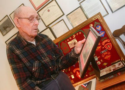 Max Cribelar, 85, WWII, Korea and Vietnam veteran, in his Jacksonville home among some of his memorabilia. Hanging on the wall behind and to his left, an image of him being presented a "Hardcore Warriors" certificate by Marine Corps Base Camp Lejeune Commanding Officer Col. Adele E. Hodges at the base’s Military Retiree Appreciation Day, Sept. 22, 2007.