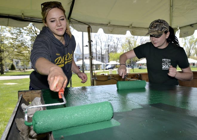 DelVal freshman Tracy Mandrona (left) and Rebecca Paoletti (right) place a fresh coat of paint one many tables at the college in preparation for A-Day this weekend at Delaware Valley College this weekend.