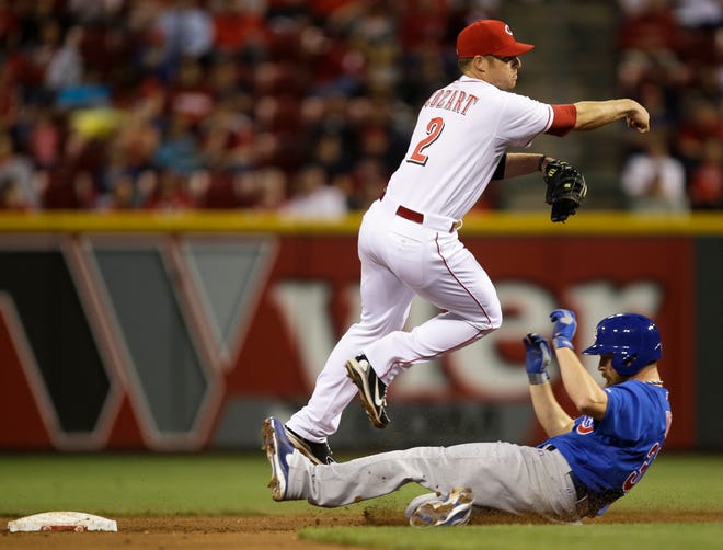 Cincinnati Reds shortstop Zack Cozart (2) throws to first to complete a double play after forcing out Chicago Cubs' Travis Wood in the fifth inning of a baseball game, Monday, April 22, 2013, in Cincinnati. (AP Photo/Al Behrman)
