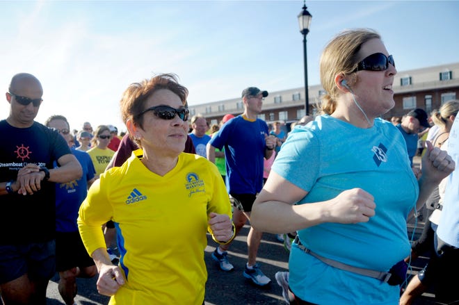 Joni Anderson of Peoria, left, who ran in the 2013 Boston Marathon, runs Monday with hundreds of others at a fun run hosted by Running Central to raise money for Boston Marathon bombing victims.