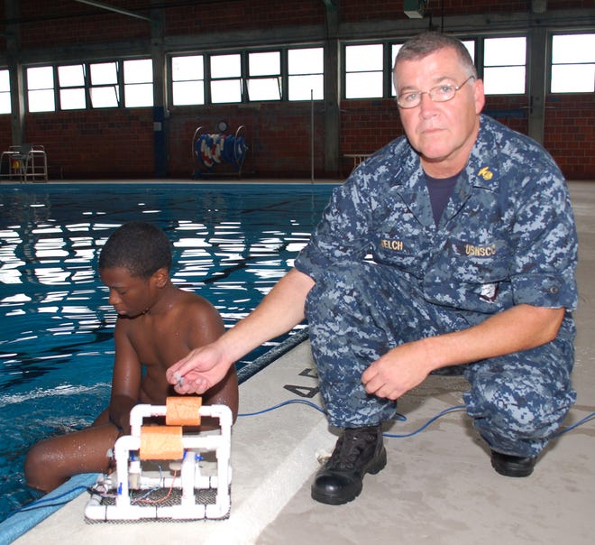 Cadet Paveon Jones and F.D. Roosevelt Squadron Executive Officer Lt. j.g. David Welch check the electrical connections on a SeaPerch - a remotely controlled craft consisting primarily of PVC pipe, styrofoam and waterproof DC motors.