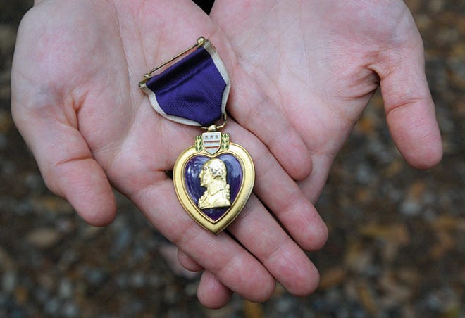Sylvia Jabaley holds the Purple Heart medal that she found in her Wilmington home. The Purple Heart was awarded to a U.S. Coast Guardsman from New Bern who died in 1944 when a German U-Boat sank his ship.