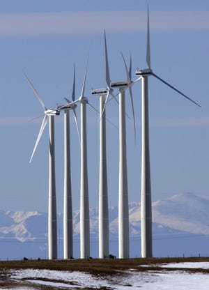The Rocky Mountains can be seen in the distance as wind mills generate electricity at the Ponnequin Wind Farm near Carr, Colo., on Jan. 29, 2007. (Ed Andrieski | Associated Press)