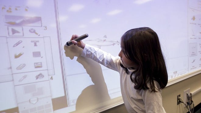 Araceli Lopez uses an electronic pen to move images projected on a board in her pre-kindergarten class at Sanchez Elementary. The Austin school district’s proposed bond package would include $140.6 million to purchase technology.