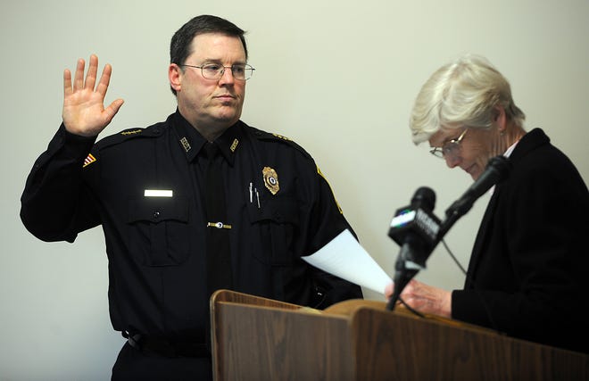 Richard Flannery is sworn in as Hopkinton's police chief by Town Clerk Ann Click at police headquarters yesterday.