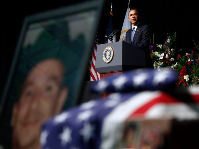 President Barack Obama is seen above a memorial for firefighter Morris Wayne Bridges, Jr., as he speaks at a memorial for firefighters killed at the fertilizer plant explosion in West, Texas, at Baylor University in Waco, Texas, Thursday, April 25, 2013. (AP Photo/Charles Dharapak)