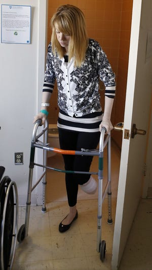 Adrianne Haslet, a a professional ballroom dancer injured by one of the bombs that exploded near the Boston Marathon finish line, uses a walker to return to her bed at Spaulding Rehabilitation Hospital in Boston on Wednesday. Haslet, who lost her left foot and part of her lower leg, vows that she will dance again. AP Photo/Bizuayehu Tesfaye