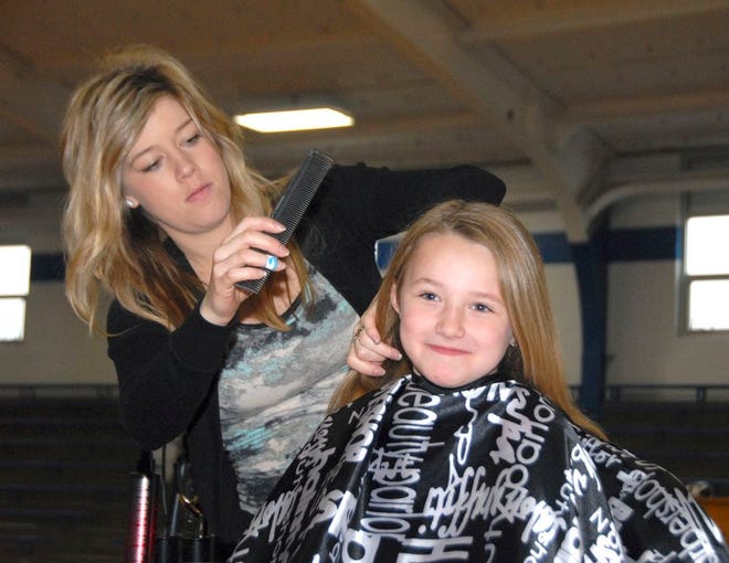Cornell Grade School student Brooklyn Swanberg, a first grader, smiled as beautician Brittany Lyons prepared her hair to be cut.