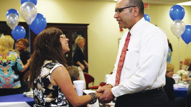 Pflugerville school district translator Maribel Hernandez shakes the hand of Superintendent Charles Dupre April 17 during a farewell reception for Dupre at the district’s administration building. Beginning next week, Dupre will begin serving as the Fort Bend school district (near Houston) superintendent. He will work for PISD through Friday.
