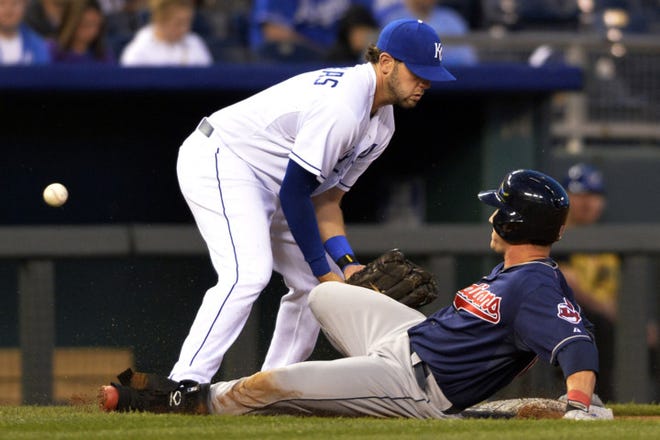 Cleveland Indians' Yan Gomes slides safely into third as the ball gets past Kansas City Royals third baseman Mike Moustakas (8) in the fourth inning of their second baseball game of a doubleheader, Sunday in Kansas City, Mo. (AP Photo/Reed Hoffmann)