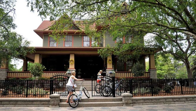 A cyclist passes the Art House at Oak Street on the second day of the preservation home tour. The house was renovated in 2003 and is the home of the Martin L. Leibowitz law firm.