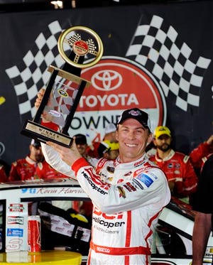 Kevin Harvick holds the trophy as he celebrates winning the Toyota Owner's 400 NASCAR Sprint Cup series auto race at Richmond International Raceway in Richmond, Va., Saturday April 27, 2013.  (AP Photo/Clem Britt)