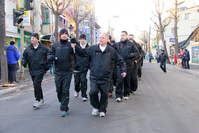 Retired FBI agent Ken Veach (right), runs with the torch during the Special Olympics World Winter Games held in South Korea in January. Veach was one of 50 law enforcement representatives from the United States with one coming from each state.