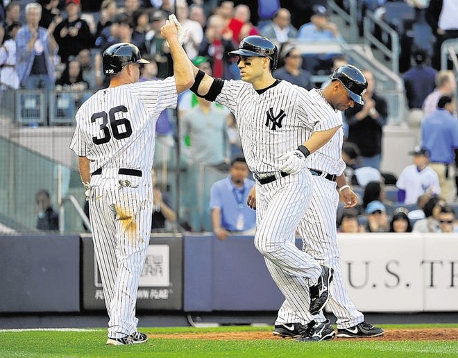 Yankees' Travis Hafner is greeted at home plate by Kevin Youkilis, left, after hitting a three-run homer Saturday in New York’s win over Toronto.