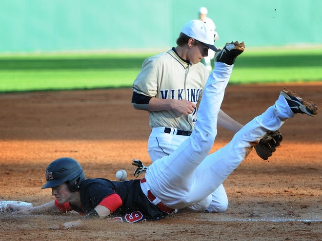 Wade Hampton’s Jackson Norrell slides safely back to third base as the ball gets away from Spartanburg’s Warren Bond on Monday at Duncan Park.