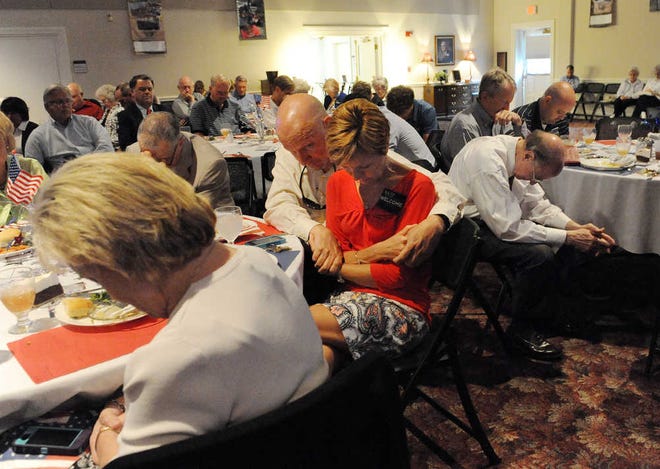 People bow their heads during a National Day of Prayer luncheon at Warren Baptist Church in Augusta.