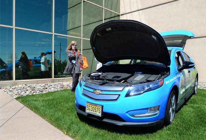 Allison Mitchell from NJBPU and Sherri Jones, NJBPU look over the Chevy Volt Electric car on display outside the Rutgers Eco Complex in Mansfield.