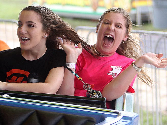 Kayla Beker, 15 (left) and Lauren Bourgeois, 15, enjoy a thrill ride Thursday evening at the Thibodaux Firemen’s Fair. The fair continues through Sunday with a parade at 11a.m.