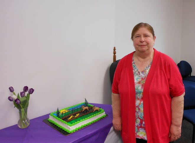 Dianne Sheaffer, Ionia County abstractor, stands beside her cake at a party in her honor Tuesday. Sheaffer retired after 45 years in the county’s abstract office.