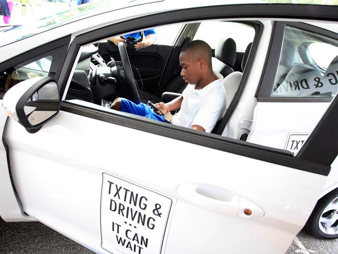 Students, including Marcus Plowden, 15, participate in the AT&T texting and driving simulator as part of their "Txtng & Drivng...It Can Wait" public awareness campaign, Friday, October 5, 2012 at Gainesville High School in Gainesville, Fla.