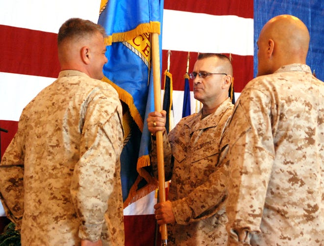 Col. Blayne H. Spratlin, center, receives the colors from Col. Mitchell A. Bauman, left, at a change of command ceremony on Thursday at Cherry Point. Spratlin took over command of Fleet Readiness Center East from Bauman, who is retiring after 32 years in the Marine Corps.