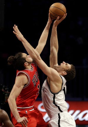 Chicago Bulls center Joakim Noah, left, blocks Brooklyn Nets center Brook Lopez during Game 7 of their first-round playoff series in New York, Saturday.