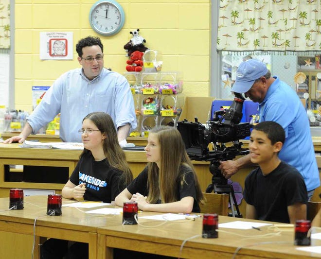 ESPN producer Zac Budman (left) directs the filming of region spelling bee champion Rachael Cundey (from left, seated), with classmates Kristen Schipper and Jacques Lee, for a profile to be shown on the network.