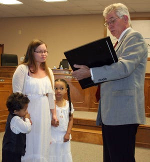 Photo by Barry L. Paschal District 4 Columbia County Commissioner Bill Morris reads a proclamation declaring Food Allergy Awareness Week for presentation to Sheena Whitlock, president of Augusta Food Allergy. She is accompanied by her son, Langston, and daughter, Ha'ani.