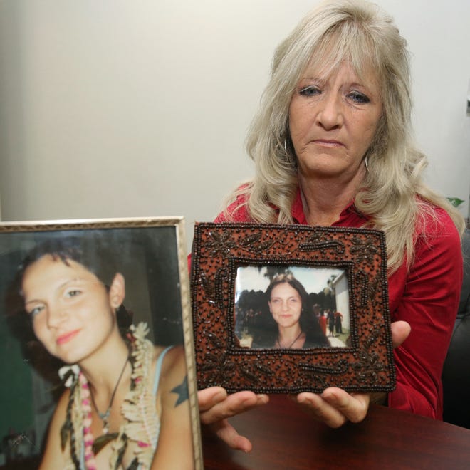 Julie Clement holds photos of her deceased daughter, Hayley Marshall, during an interview at the Marion County Sheriff's Office in Ocala, Fla. on Tuesday, May 7, 2013.