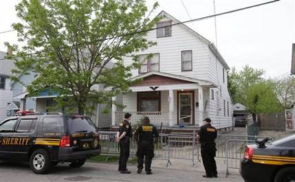 Sheriff deputies stand outside a house in Cleveland Tuesday, May 7, 2013, the day after three women who vanished a decade ago were found there.