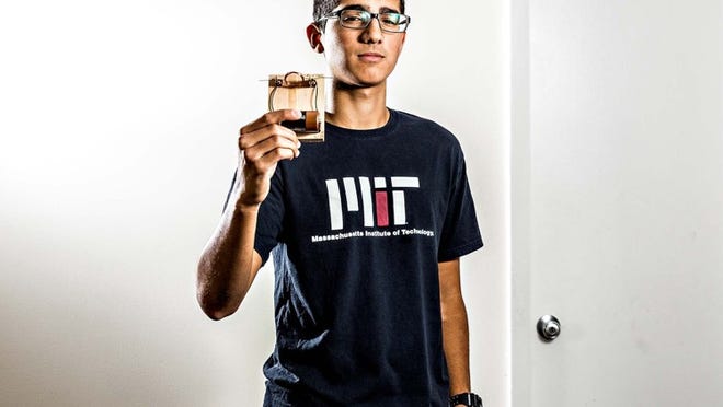 Wellington High School valedictorian Sina Booeshaghi with an electric motor he built in the sixth grade. (Thomas Cordy/The Palm Beach Post)