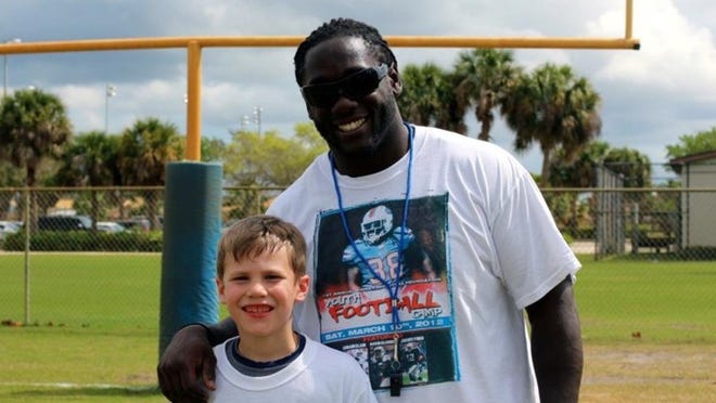 Corey McIntyre with a young fan at his foundation’s inaugural Youth Football Camp held in Port St. Lucie on March 10, 2012.