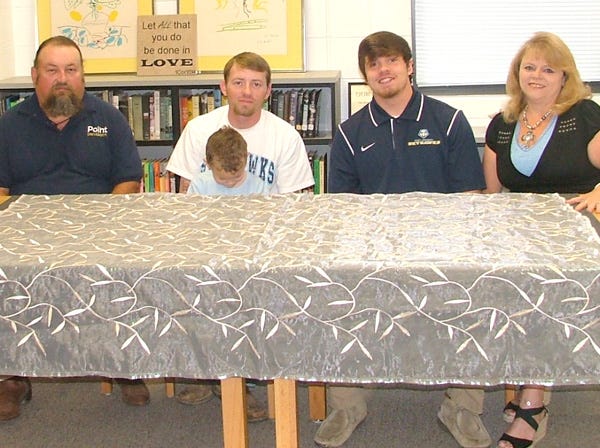 Glencoe's Dalton Gowens, second from right, signed a football scholarship with Point University on Wednesday. Also seated, from left, are Gowens' father Greg, brother Tyler (holding his son Everett) and mother Angie.