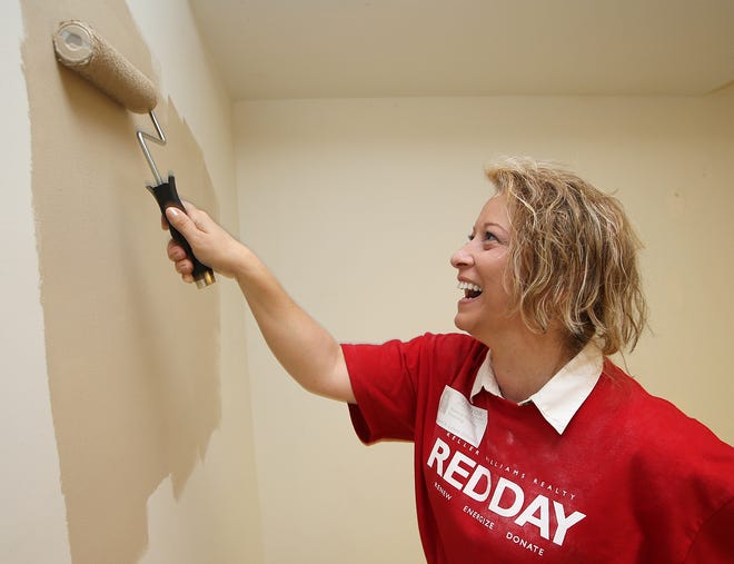 Nancy Healey paints the auditorium at the Margaret K. Lewis School in Millville on Thursday. Healey was one of several real estate agents from Keller Williams Success Realty on hand for the Renew, Energize and Donate Day for real estate professionals.