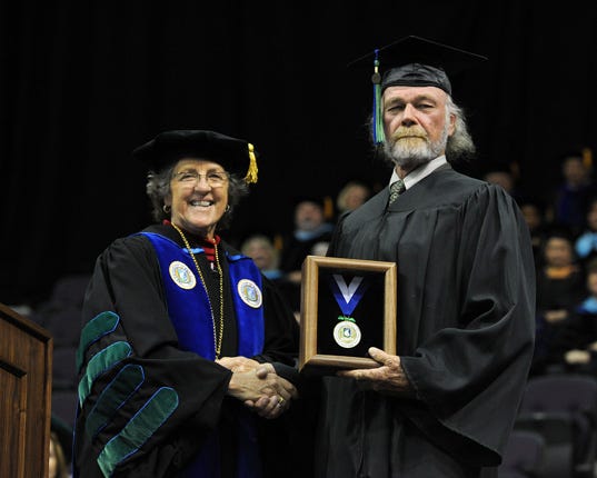 Bruce Cheves receives the Presidential Medal of Honor from UWF President Judy Bense during the Spring Commencement ceremony on Saturday, May 4.