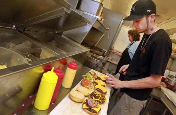 (Photo by Mike Hensdill/The Gaston Gazette) The Catawba BBQ & Grill is open on East Catawba Street in Belmont. Here, Jeremy Edge (foreground) and Kathleen Hover cook up burgers and fries in the kitchen Friday afternoon, May 3, 2013.