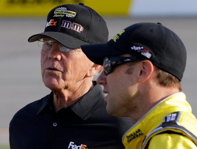 Team owner Joe Gibbs, left, talks with driver Matt Kenseth during qualifying for the NASCAR Sprint Cup series auto race at Richmond International Raceway in Richmond, Va. A NASCAR appeals panel sided with Joe Gibbs Racing on Wednesday and eased some of the penalties imposed for having an illegal part in Kenseth's race-winning engine at Kansas last month.