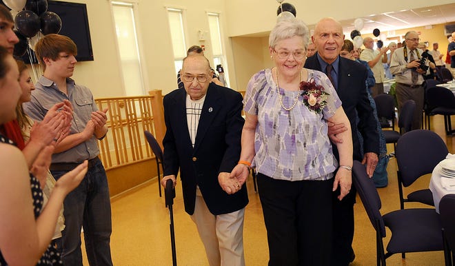 Joan Motuzas, 74, center, the Milford Senior of the Year, enters the Milford Senior Center escorted by Stanley Nalewajko, left, and Vincent Squiciari of the Council on Aging, for the annual volunteer recognition and Senior of the Year luncheon.