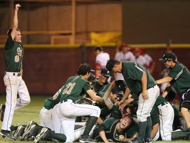 Trinity Catholic's #8 Kevin Teaf, left, celebrates as the rest of his team pile up on the field after defeating Satellite High School 14-1 in 6 innings Friday night at Satellite High School.