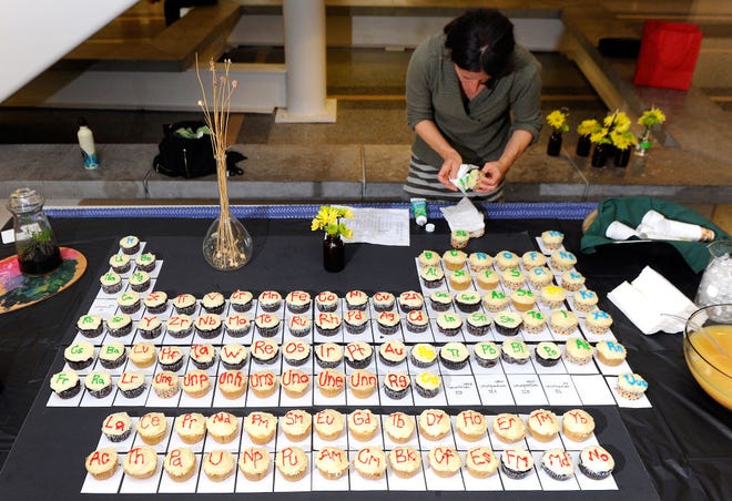 Amanda Wolfgeher, a soil science student at the University of Missouri, decorates cupcakes with symbols from the Periodic Table of Elements yesterday at the Science Communication and Public Engagement event at the McQuinn Atrium of the Bond Life Sciences Center.