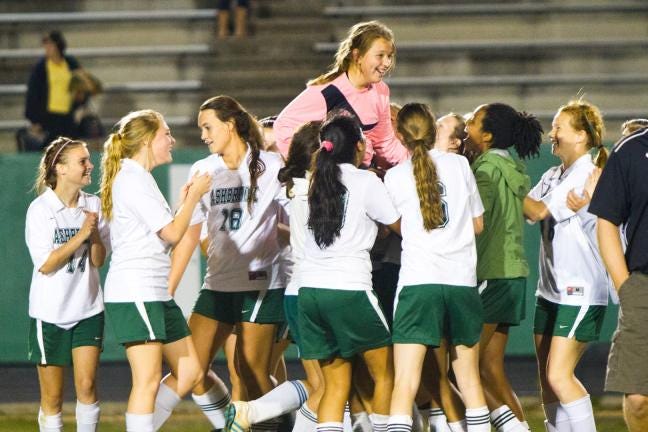 Ashbrook players hoist goalkeeper Conner McCuen as she saved the final penalty kick in Ashbrook's win over Fred T. Foard on Saturday.