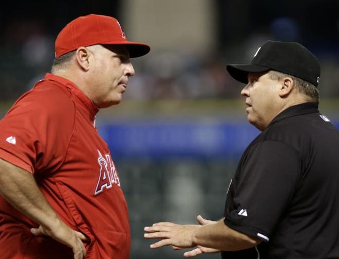 Los Angeles Angels manager Mike Scioscia, left, argues a close play at first base with umpire Fieldin Culbreth in the second inning of a baseball game against the Houston Astros, Thursday, May 9, 2013, in Houston.