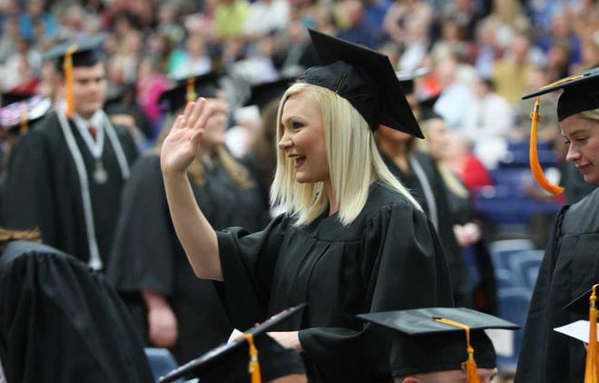 Amy Clements waves to an audience member at the start of Saturday's commencement ceremony at Washburn University's Lee Arena. Clements received a bachelor of science degree in nursing.