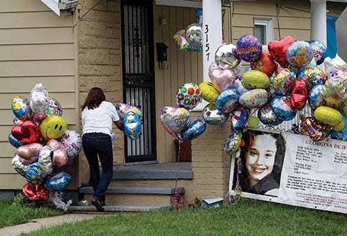 Culema Nevarez adds balloons to a growing tribute outside the home of Gina DeJesus in Cleveland, Friday, May 10, 2013. DeJesus was freed Monday from the home of Ariel Castro where she and two other women had been held captive for nearly a decade. (AP Photo/Mark Duncan)