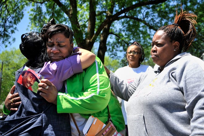 Carla Caldwell-Thomas of Peoria, whose son Brandon Thomas was shot to death in April, is comforted by Sharon Keeton, left, an evangelist with the New Life Covenant Church in Chicago, and longtime friend Dorothy Walker during a rally sponsored by the Peoria Association of Pastors for Community and Spiritual Renewal on Saturday at Warren and Butler streets.